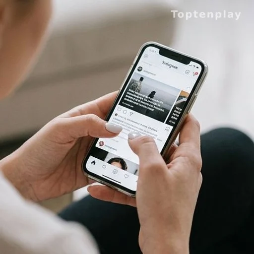 Mains sur un smartphone avec interface Instagram, silence sur les accusations Bruel