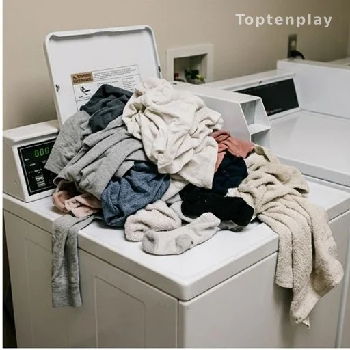 Linge laissé en attente sur une machine à laver dans une buanderie d'immeuble