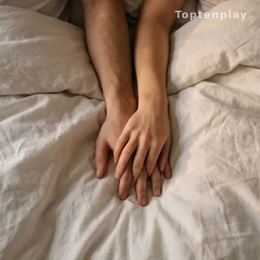 Mains enlacées sur un lit, intimité et confiance dans le couple, bien-être sexuel