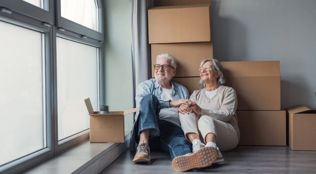 An,Elderly,Couple,Sits,On,The,Floor,Amid,Cardboard,Boxes, 30-000-euros-pour-acheter-une-maison-dans-les-poui cover