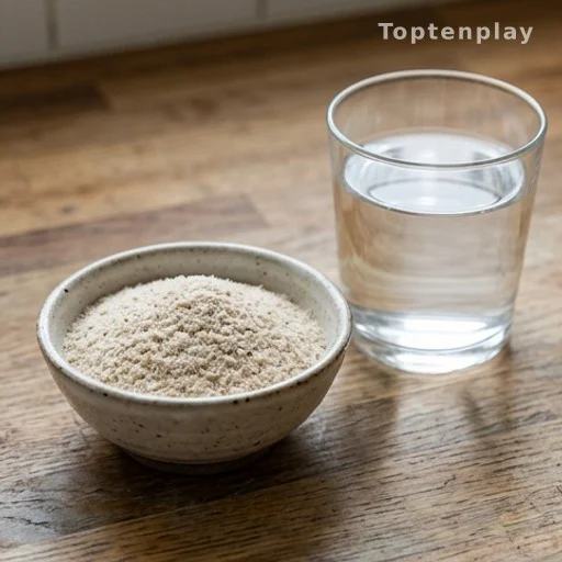 Poudre de psyllium dans un bol et verre d'eau sur un plan de travail